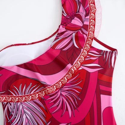 Red one-piece swimsuit with a single ruffled shoulder,paired with a matching short skirt